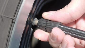 neumático inflado. la mano del hombre abre la tapa de la válvula e infla el neumático del camión antes de conducir. video