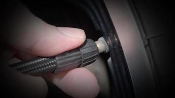 neumático inflado. la mano del hombre abre la tapa de la válvula e infla el neumático del camión antes de conducir.