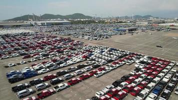 Aerial.new car storage parking lot showing imported new vehicles or ready to export new automobiles storage facility car industry for export all over the world market for car sales video