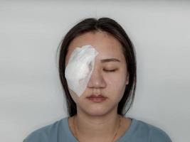 Systemic eye woman being treated from Hordeolum disease By piercing and scraping the pus out and covering it with a gauze cloth. photo