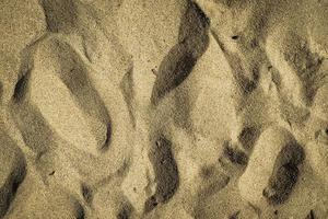 cerrar la textura de la arena en la playa como fondo foto