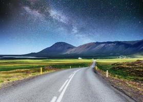 Starry Sky over the mountains. The asphalt road