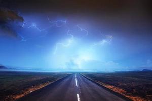 relámpagos en el cielo oscuro y nublado y hermosa carretera asfaltada. anual foto