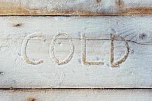 Writing on the snow. Wooden texture. photo