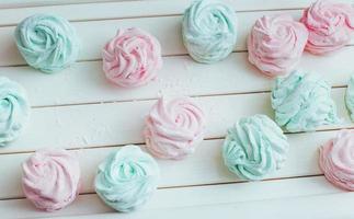 Delicious homemade marshmallow different colors on a white wooden surface. photo