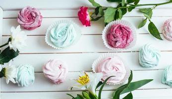 Rose marshmallows and beautiful flowers on a white background wo photo