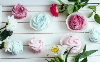 Rose marshmallows and beautiful flowers on a white background wo photo