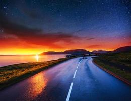 cielo estrellado sobre las montañas. la carretera asfaltada foto