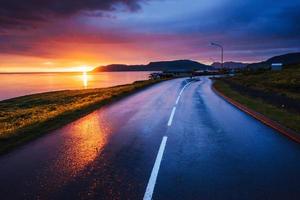 Asphalt road along the sea at sunset Iceland photo