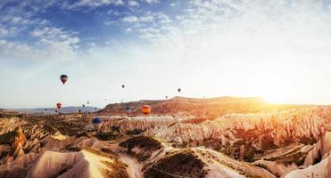 Hot air balloon flying over rock landscape at Turkey. Cappadocia photo