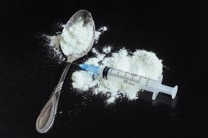 drug use, addiction and substance abuse concept - close up of spoon  syringe with crack cocaine  dose photo