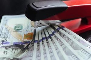 dollars and stapler on a black background photo