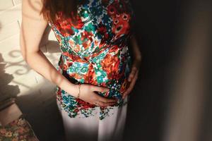 pregnant woman in a beautiful dress. Focus on the abdomen. photo