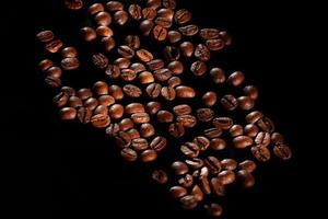 scattered coffee beans. fragrant coffee on the table. coffee is large. coffee on a black background. photo
