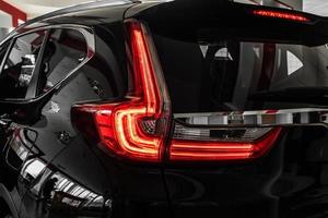 Modern luxury car close-up. Concept of expensive, sports auto. Headlight lamp of new cars,copy space. Luxury red super car details view, elegant and beautiful. Super Car back brake light view,