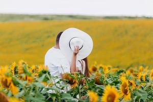 Loving couple kissing in a field of sunflowers. Family spending time together on nature. selective focus