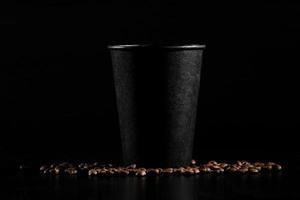 black paper glass on black background. coffee beans on a dark background. good morning photo