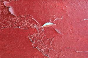 Wooden texture with cracked paint. texture of cracked from time painted red door photo