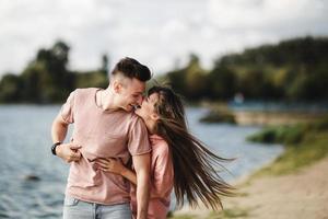 Loving young couple kissing and hugging in outdoors. Love and tenderness, dating, romance, family, anniversary concept. photo