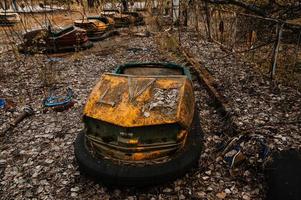 parque de atracciones abandonado con coches oxidados en la ciudad de pripyat en la zona de exclusión de chernobyl. foto