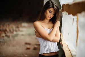 Close up portrait of young cute brunette girl posed on abandoned place.