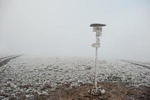 Frozen pointer with directional arrows at mountains photo