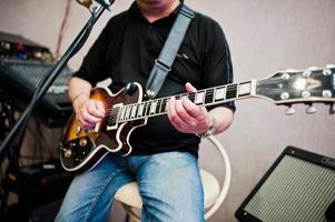 Man playing on electric guitar at stage. photo