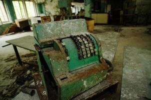 Old rusty soviet calculating machine at Chernobyl city zone of radioactivity ghost town. photo