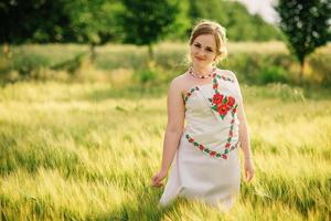 Young girl at ukrainian national dress posed at wreath field. photo