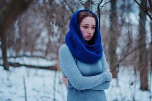 Portrait of young red hair girl with freckles wearing at blue knitted wool scarf in winter day. photo