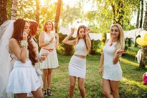 Girls wearing on white dresses having fun on hen party. photo