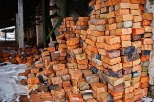 Large pile of old bricks at plant outdoor with snow. photo