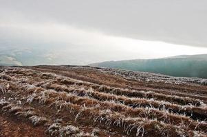 Mountain hill road up with frost grass. photo