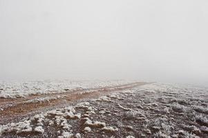 Road to nowhere. Frozen road on foggy mountain photo