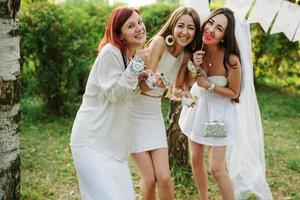 Girls wearing on white dresses having fun on hen party. photo