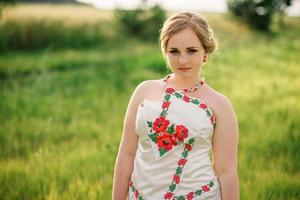 Young girl at ukrainian national dress posed at wreath field. photo