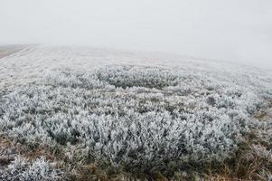 Hole in the mountain at frozen grass on hill. photo