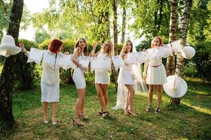 Girls wearing on white dresses having fun on hen party. photo