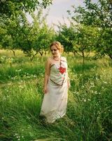 niña en vestido nacional ucraniano posó en el jardín de primavera. foto