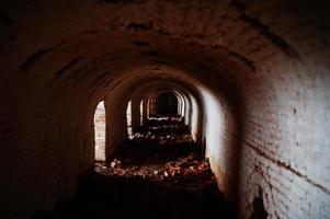 Scary brick arch tunnel on dark and some light. photo