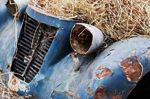 Old abandoned car with hay on engine photo