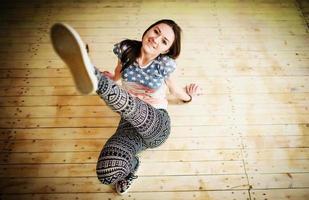 Street dancer girl wearing casual clothes on footless sitting background wooden parquet indoor. photo