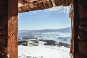 Cabin in the mountains in winter. Mysterious fog. In anticipatio photo