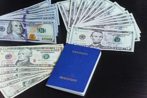 Top view of passport with dollar banknotes on wooden desktop photo