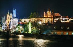 Charles Bridge with statues and Prague Castle at night. Beautiful urban lighting. , Czech Republic photo