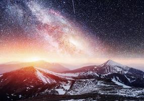 Fantastic starry sky. Beautiful winter landscape and snow-capped photo