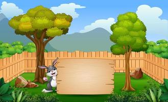 Cartoon a bunny holding blank sign in the park vector