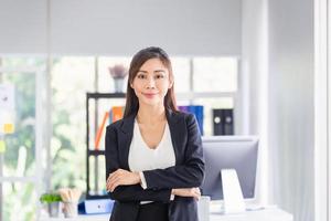 Casual business woman with arms crossed, Portrait smiling woman standing in modern office with arms crossed photo