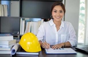 Beautiful Asian engineering women checking document and using notebook working from home for social distance and self responsibility concept photo