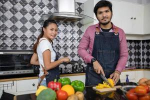 Happy and Smiling young couple cooking food in the kitchen at home photo